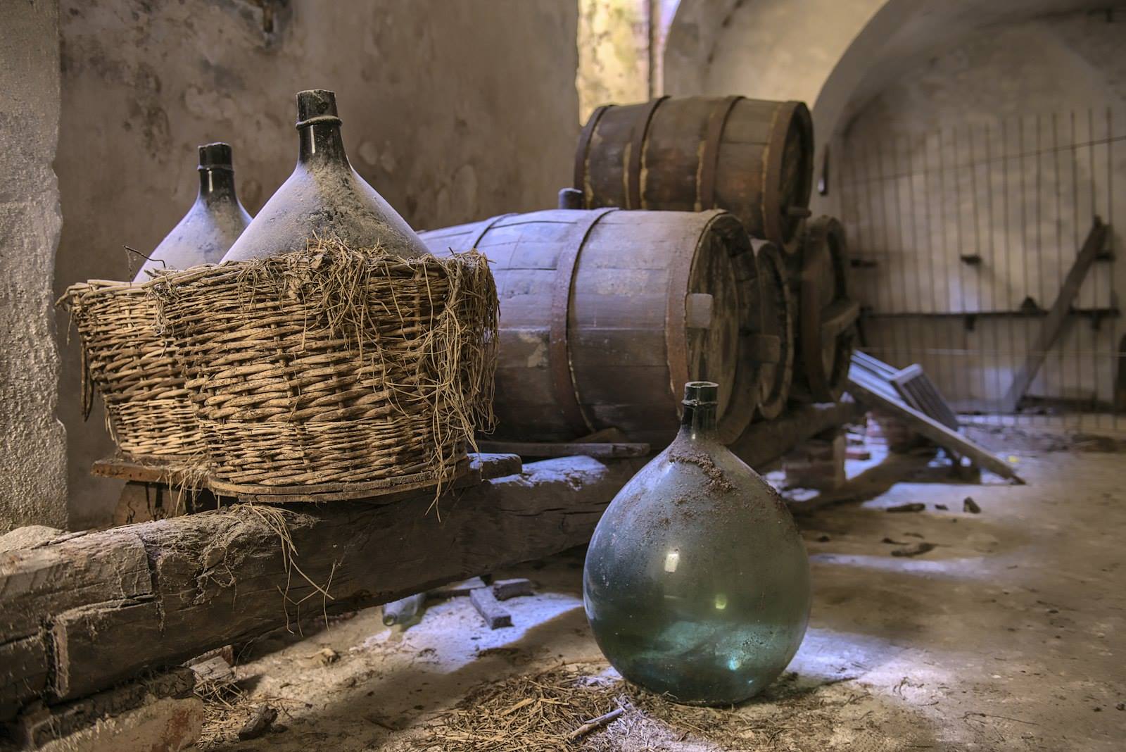 Damigiane e botti antiche in una cantina